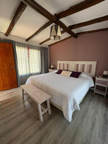a bedroom with a large bed and a table at Moller masi inti wayra in Purmamarca