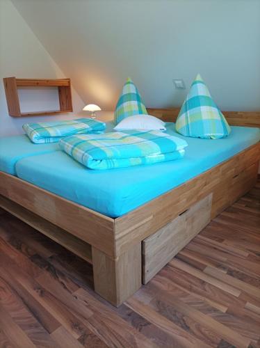 a bed in a room with blue sheets and pillows at Ferienhaus Rudolf in Achberg