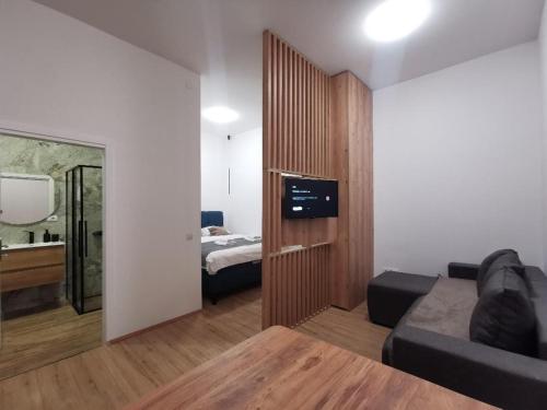 a room with a bed and a couch and a television at 369 Apartments in Belgrade