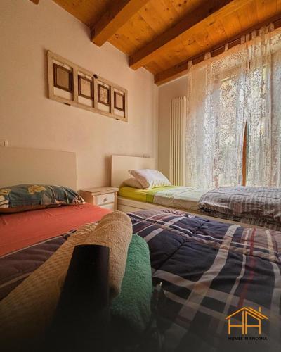a bedroom with two beds and a window at La casa di Agnese by Homes in Ancona in Ancona