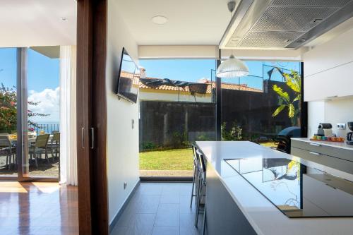 a kitchen with a counter and a large window at Villa Ocean Sight by LovelyStay in Funchal
