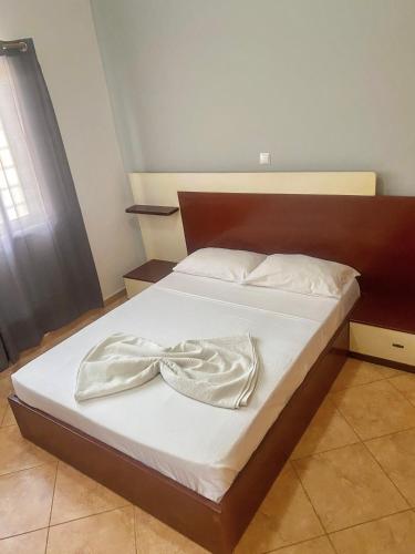 un lit avec des draps blancs et une tête de lit en bois dans l'établissement Apartamento espaçoso, à Santa Maria