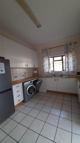 a kitchen with a washing machine and a sink at House with Those Stairs in Langebaan