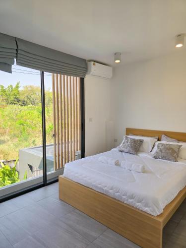 a bedroom with a large bed and a balcony at AURA STAY-Luxury Private Pool Villa walk to Kad Farang in Chiang Mai