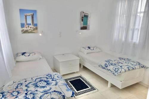 two beds in a room with blue and white at Villa E - Kamari Village in Kastraki