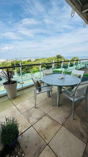 a patio with a table and chairs on a balcony at Quayside Apartment - Large and Spacious Duplex in Castletown