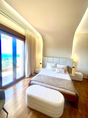 a bedroom with a large bed and a large window at Presidential Sea View in Mytilene