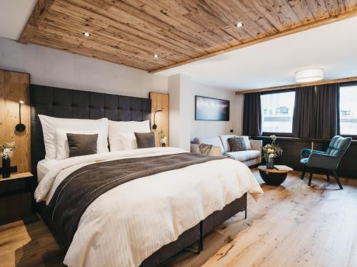a bedroom with a large bed and a chair at VAYA Nauders in Nauders