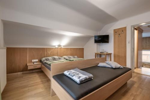 a bedroom with two beds and a flat screen tv at Alpenchalet Mitterlechner in Bad Hofgastein