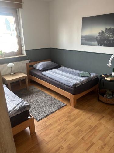 a bedroom with two beds and a rug at Palms Zimmer in Frechen
