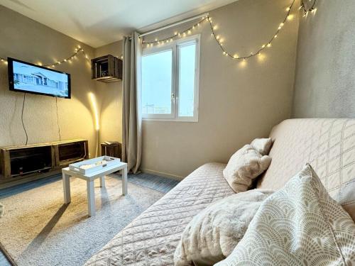 a room with a bed and a tv and a table at Vacances à la mer - studio in Calais