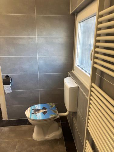 a bathroom with a toilet with a bowl on it at Palms Zimmer in Frechen