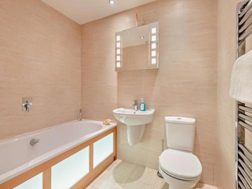 a bathroom with a toilet and a sink and a bath tub at 2 Bed in West Bay oc-dc065 in West Bay