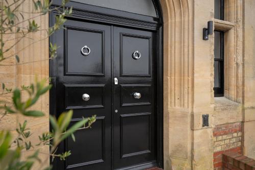 a black door with silver knobs on a building at No 4 The Halesworth in Halesworth