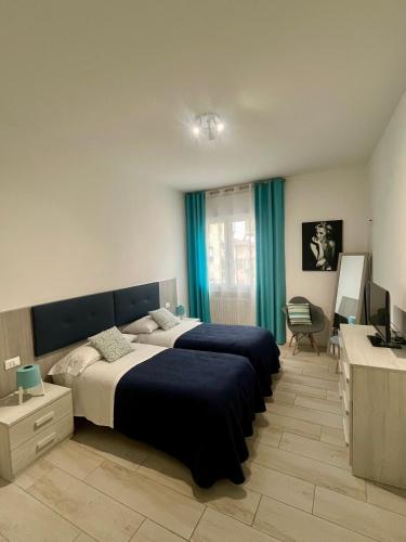 a bedroom with two beds and a desk and a television at Yaya's House - Venice in Mestre