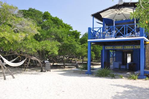 a blue building on the beach with a hammock at Casa Gaviota Baru Beach House in Baru