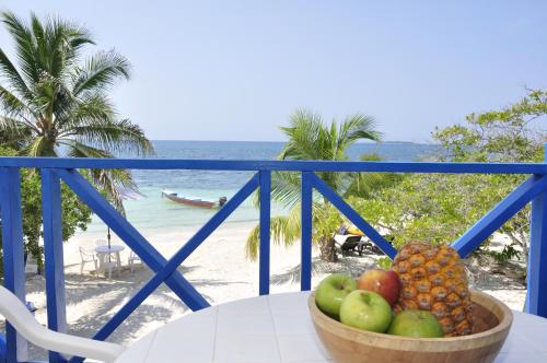 a bowl of fruit sitting on a table on a beach at Casa Gaviota Baru Beach House in Baru
