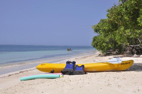 a yellow kayak and a raft on a beach at Casa Gaviota Baru Beach House in Baru