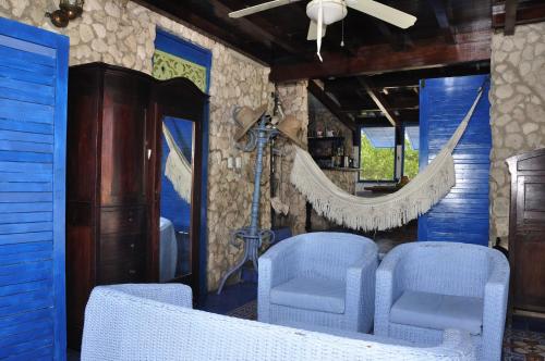 a dining room with blue chairs and a ceiling fan at Casa Gaviota Baru Beach House in Baru