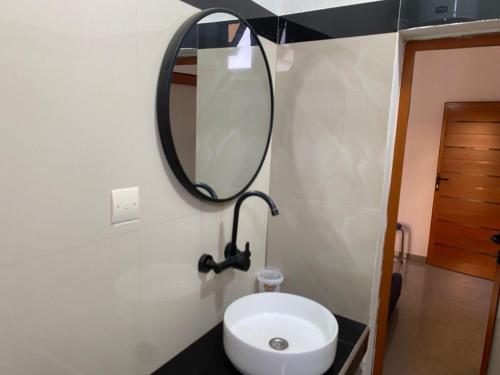 a bathroom with a white toilet and a mirror at Studio triomphe in Saly Portudal