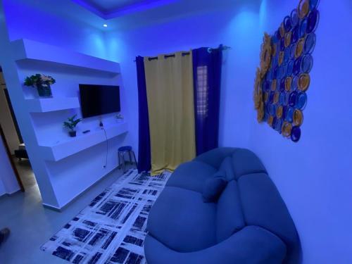 a blue room with a blue couch and a television at Studio triomphe in Saly Portudal