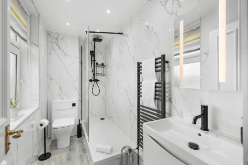 a white bathroom with a toilet and a sink at Birdies Nest in Carnoustie