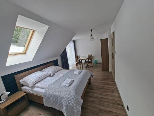 a bedroom with a bed and a table and a window at Agroturystyka Julinka in Olszyny