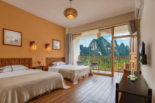 a hotel room with two beds and a large window at Serenity Inn in Gaotian