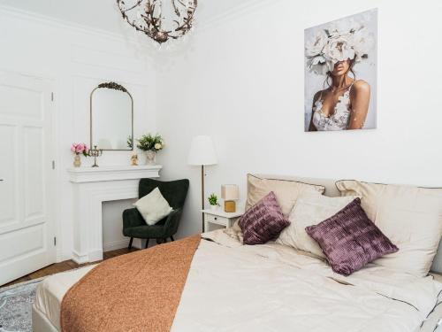 a white bedroom with a bed and a chair at Altstadt Geverdes 3 in Lübeck