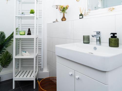 a white bathroom with a sink and a mirror at Altstadt Geverdes 3 in Lübeck
