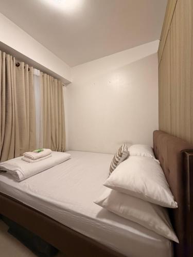 a bed with two pillows on it in a room at Shore Residences TowerA in Manila