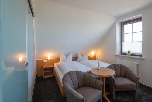 a bedroom with a bed and two chairs and a table at Hotel Strandräuber in Kalifornien