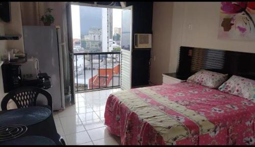 a bedroom with a bed and a balcony with a view at Suíte panorama histórico in Manaus