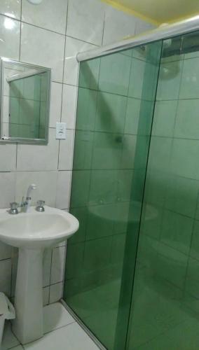 a bathroom with a sink and a glass shower at Suíte panorama histórico in Manaus
