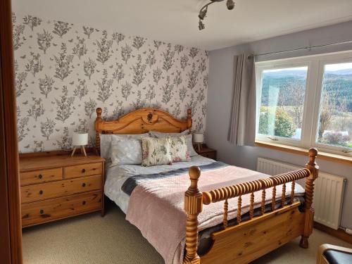 a bedroom with a wooden bed and a window at The Studio in Drumnadrochit