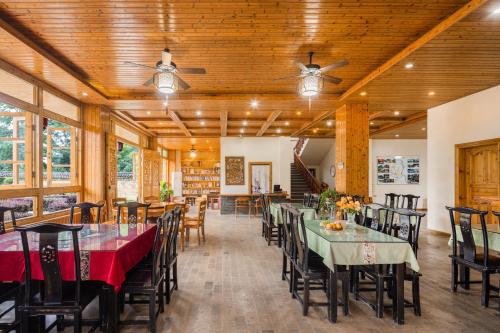 a dining room with tables and chairs and wooden ceilings at Serenity Inn in Gaotian