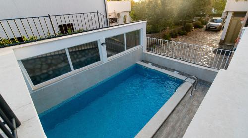 a swimming pool on the balcony of a house at Guest house Lavanda 2 in Njivice