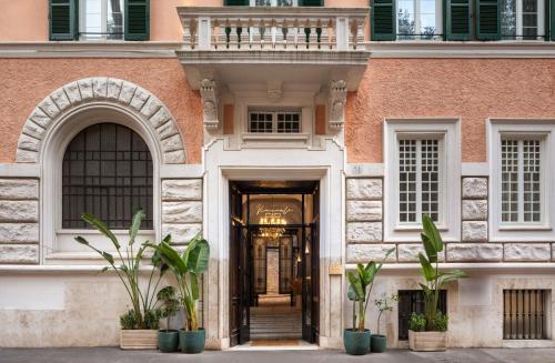 an entrance to a pink building with plants in front at Hotel Viminale in Rome