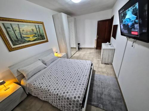 a bedroom with a bed and a flat screen tv at House Riky in Assemini