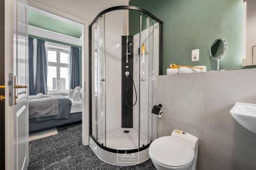 a bathroom with a shower with a toilet and a bed at Art Apartments in Hamburg