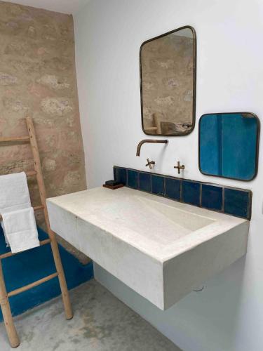 a bathroom with a sink and a mirror and a chair at Idyllic lodge in Essaouira