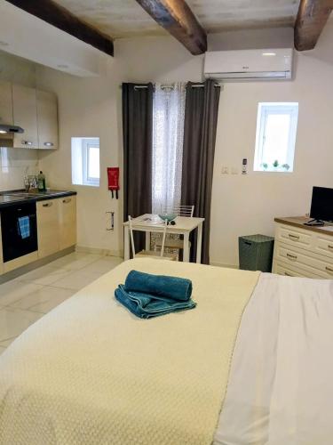 Un dormitorio con una cama grande con una toalla azul encima. en Valletta Malta, en Floriana