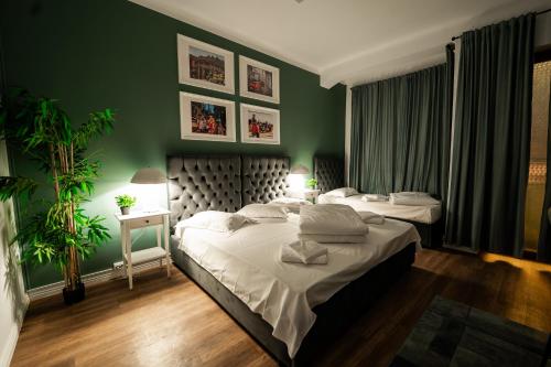 a bedroom with two beds and a green wall at Pit Stop Baby in Ploieşti