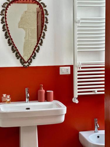 a bathroom with a white sink and a mirror at Convers'Amo Home in Conversano