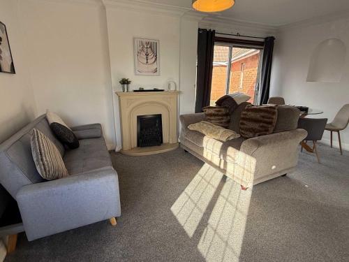 a living room with two couches and a fireplace at Large 4 Bed with Parking in Hillmorton