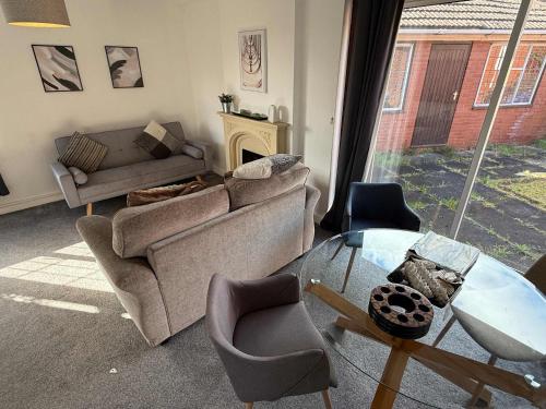 a living room with a couch and a glass table at Large 4 Bed with Parking in Hillmorton