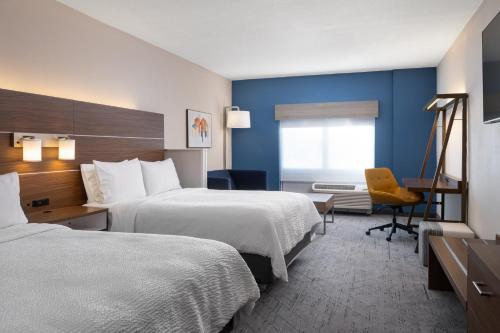 a hotel room with two beds and a desk at Holiday Inn Express & Suites Trinity by IHG in Trinity