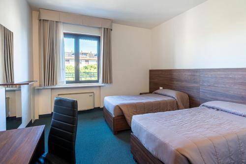 a hotel room with two beds and a table at Venice Hotel Albatros in Mestre