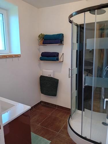a bathroom with a shower and three folded towels at Le gîte d'Elisa in Roullours