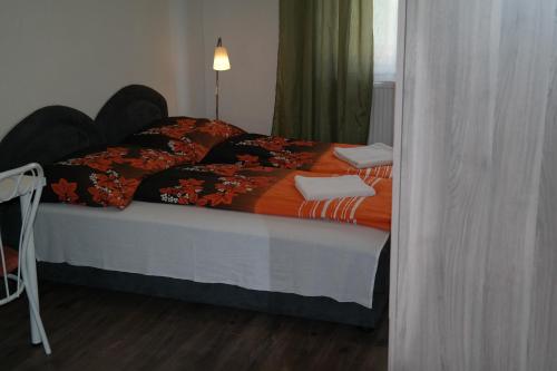 a bedroom with a bed with an orange comforter at West City Apartments in Budapest